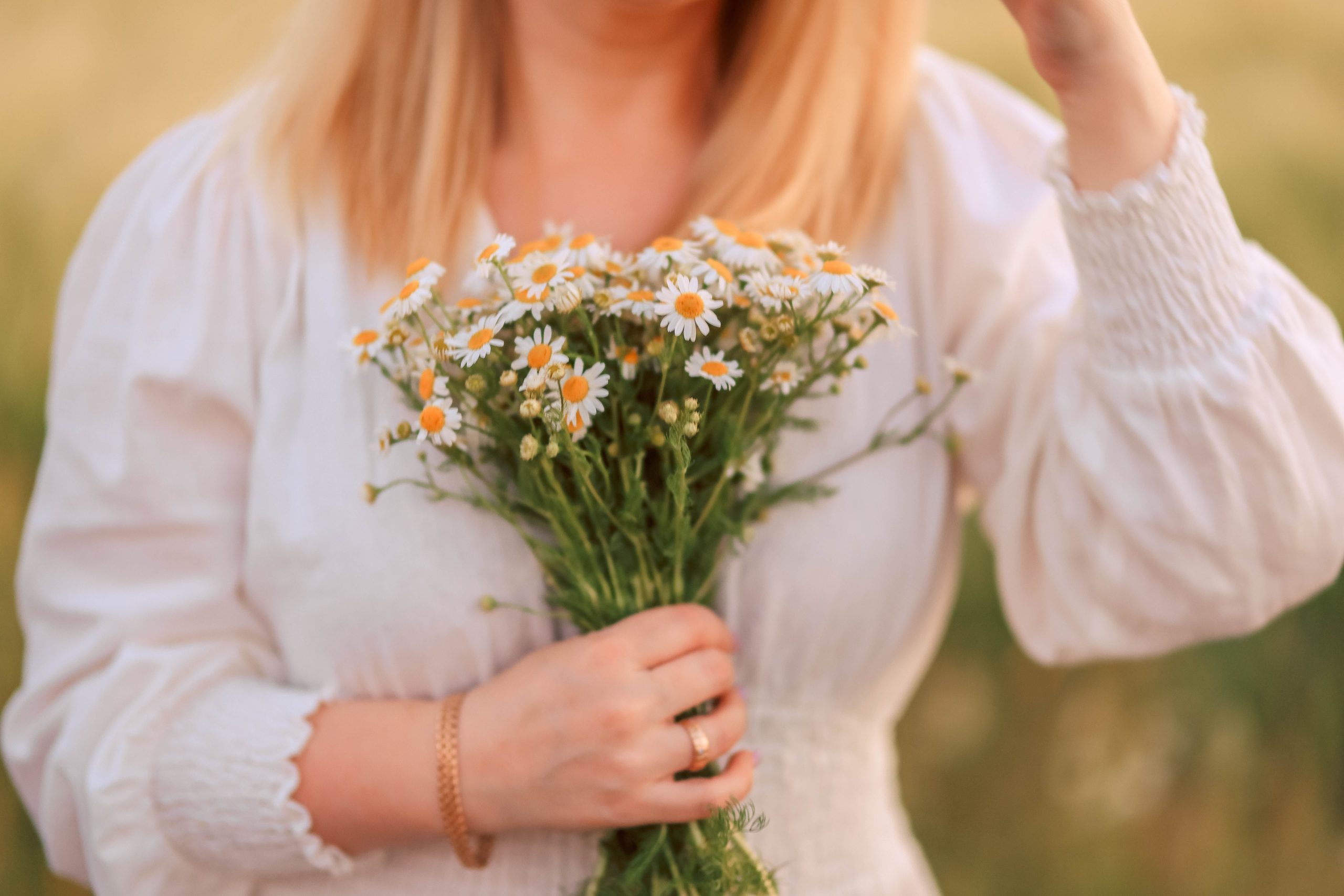 Woman holding a bouquet of daisies outdoors